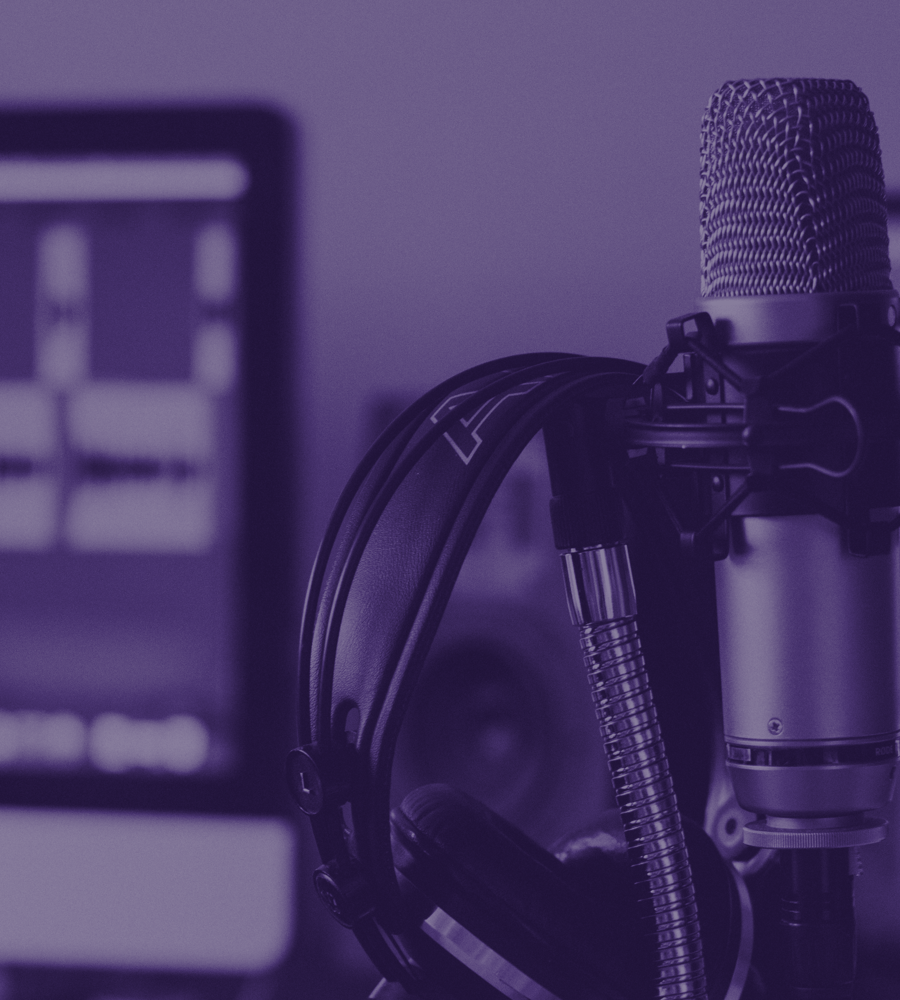A studio microphone, headphones, and audio workstation